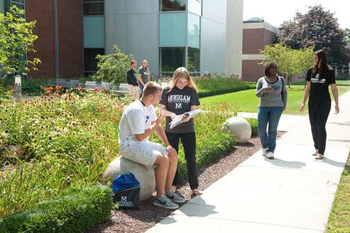 Students conversing in Cardinal Square butterfly garden area